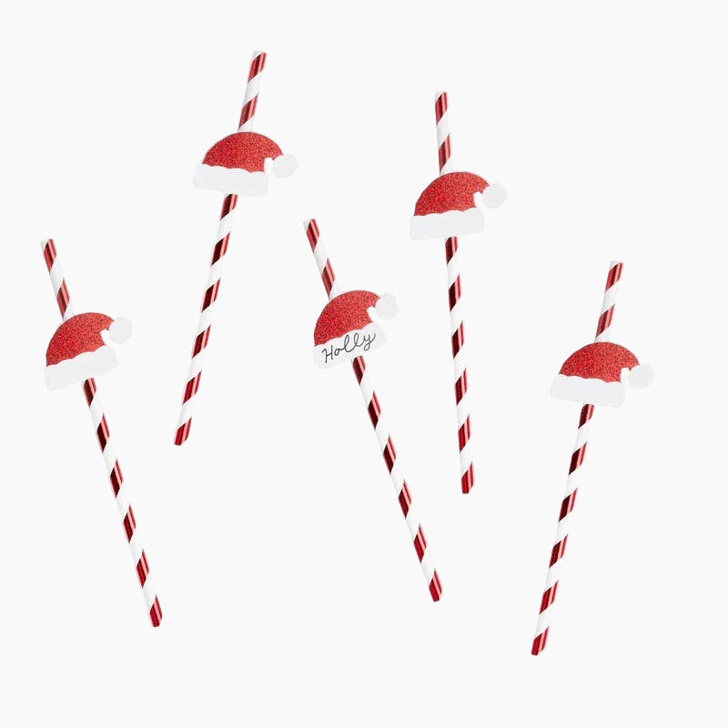 Red and white striped straws with Santa hats on a white background