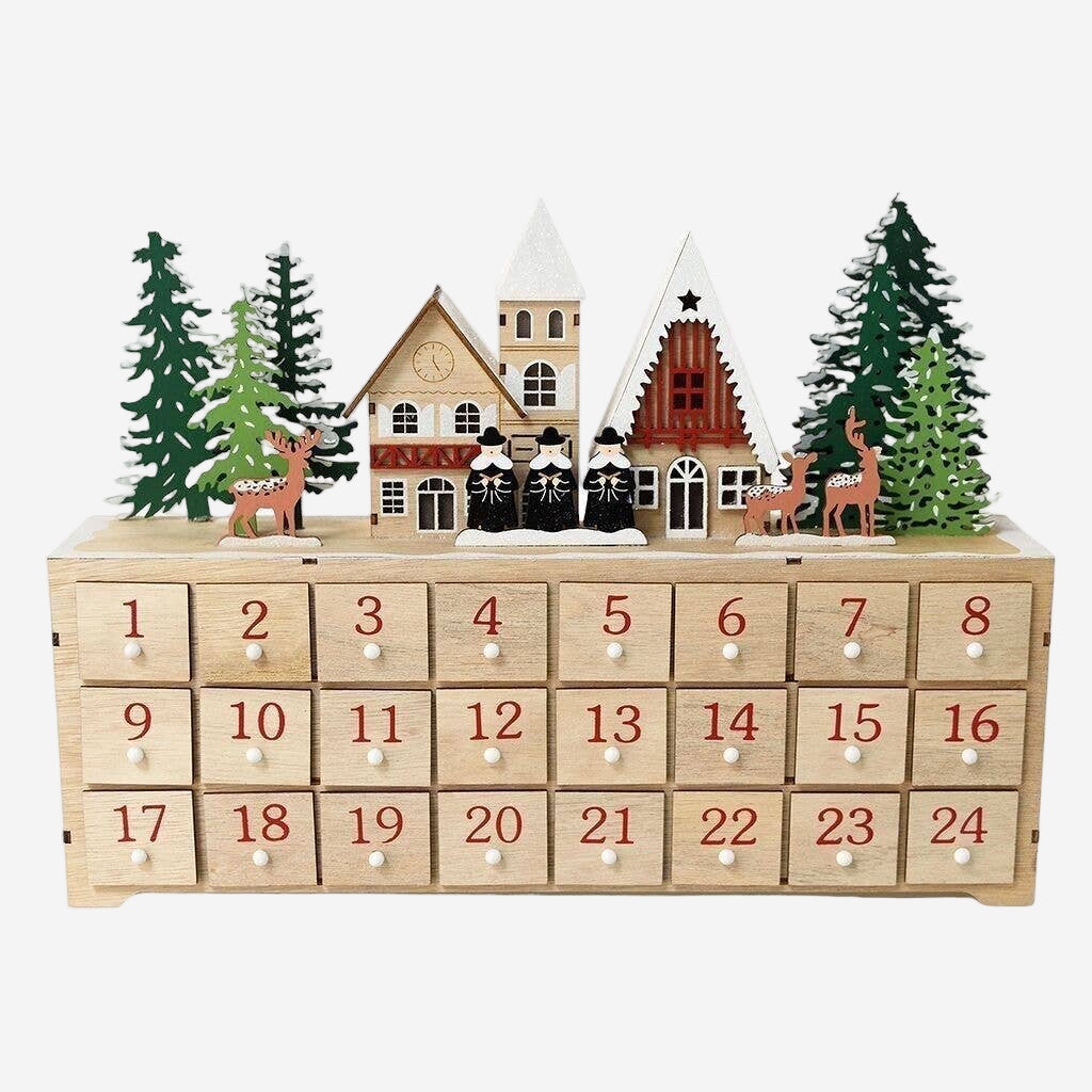 Wooden advent calendar with Christmas village scene and trees on a white background