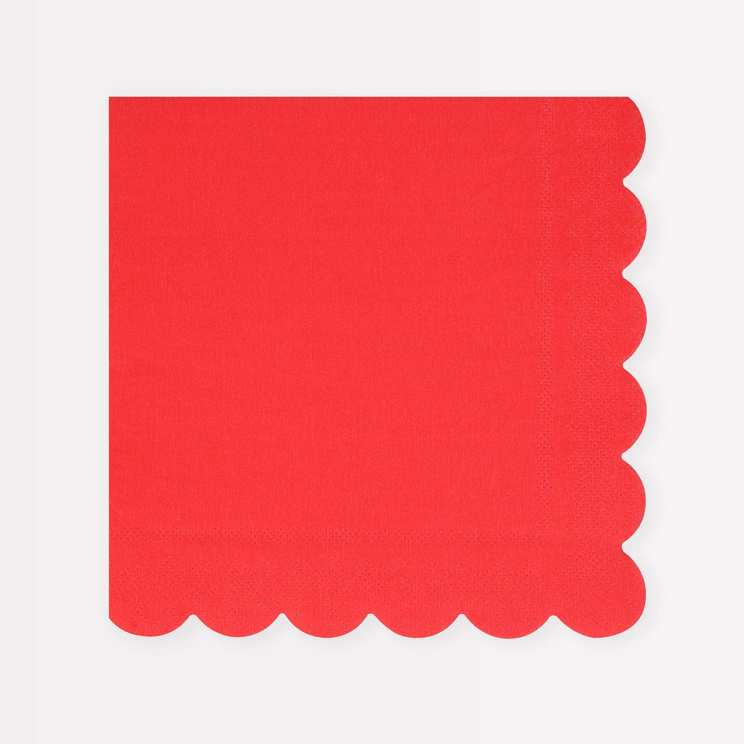 Red napkin with scalloped edge on a white background