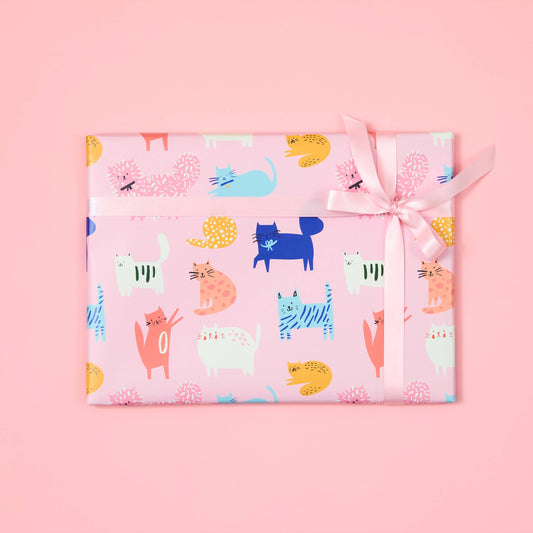 Gift wrapped in colorful animal patterned paper with a pink background