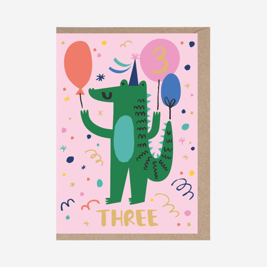 Children's birthday card with a green dinosaur holding balloons on a pink background