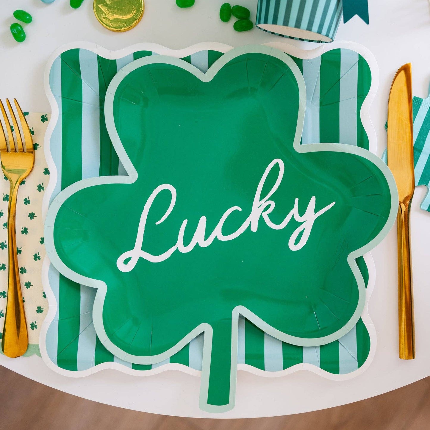Green shamrock-shaped plate with 'Lucky' text on a festive table setting.