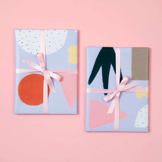 Two gift boxes with abstract designs and ribbons on a pink background
