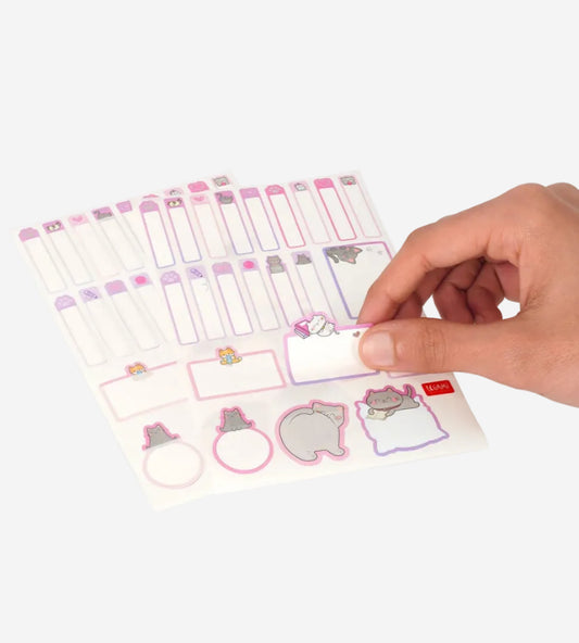 Sheet of planner stickers with cute designs, held by a hand on a white background