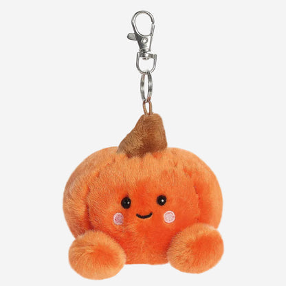 A cute orange plush pumpkin keychain with a smiling face, embroidered eyes and mouth, pink cheek details, and a brown stem, attached to a silver metal swivel clasp on a plain white background.
