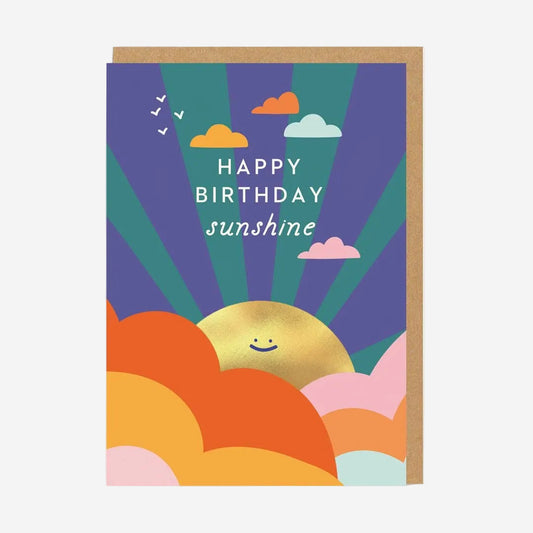 A greeting card with a colorful front design featuring text 'Happy Birthday' and the word 'Sunshine' with a graphic of a sun and clouds.